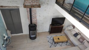 A modern living room with a fireplace, sofa, TV, and a small wooden table.