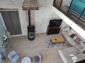 A modern living room with a fireplace, sofa, TV, and a small wooden table.