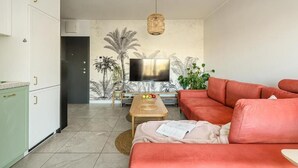 Ein modernes Wohnzimmer mit einer Couch, einem Couchtisch und einem Fernseher.