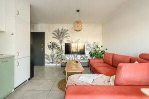 A modern living room with a sofa, a coffee table, and a TV. - ShortStayPoland Szwedzka B109 (Warszawa)