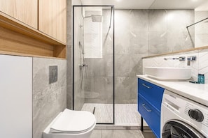 Luxe appartement, balkon, uitzicht op binnenplaats | Badkamer | Een douche, een haardroger, handdoeken, zeep