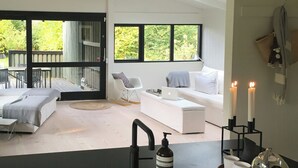 A modern kitchen with a black countertop, a sink, and a dining area with a table and chairs. - Architect-designed 80s house by Hornbæk (Hornbæk)