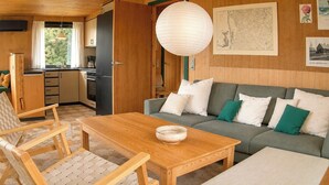 Ein gemütliches Wohnzimmer mit einer Couch, einem Holztisch und einem Sessel.