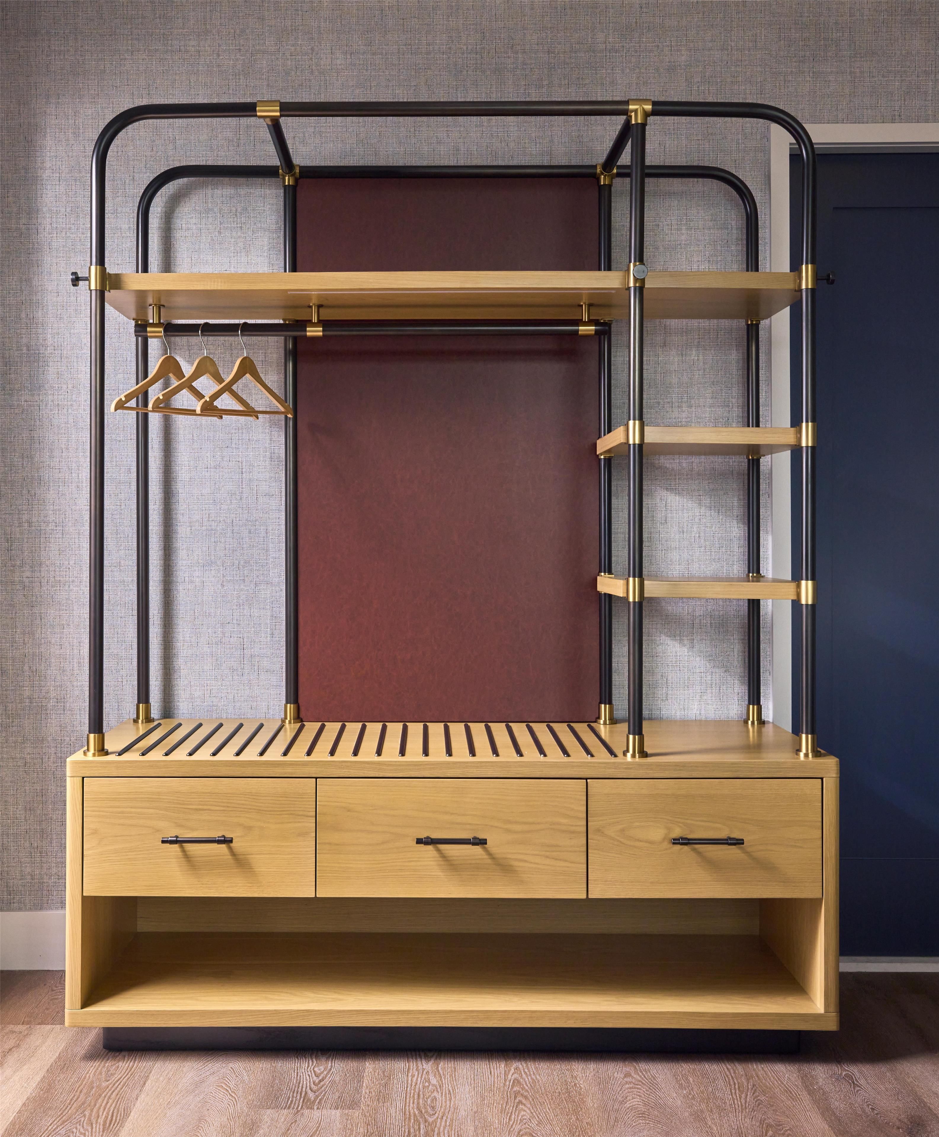 A bunk bed with a wooden base and drawers, a red mattress, and metal railings.