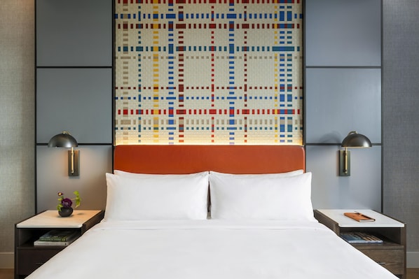 A hotel room with a large bed, two bedside tables, a wall-mounted lamp, and a colorful mosaic headboard. - Canopy by Hilton Deer Valley (Park City)