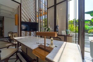 Eine moderne Hotelhalle mit einer Marmor-Rezeption, einem Flachbildfernseher und einer Concierge-Theke.