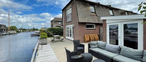 A waterfront property with a patio, outdoor seating, and a view of the water.