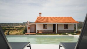 Ett hus med en swimmingpool, en uteplats och utsikt över landsbygden.