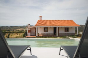 Ein Haus mit Swimmingpool, Terrasse und Blick auf die Landschaft.