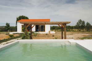 Une maison moderne dotée d’une piscine, d’une pergola en bois et d’une façade blanche.