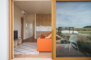 Ein modernes Interieur mit einer Couch, einem Fernseher und einer Küchenzeile.