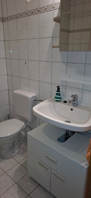 Ein Badezimmer mit Toilette, Waschbecken und Schrank.