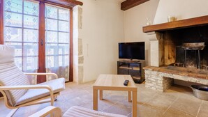 A living room with a fireplace, a TV, and a sofa.