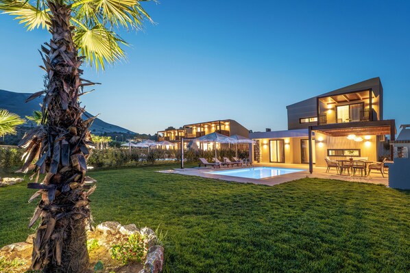 A modern house with a swimming pool, outdoor seating, and a well-maintained lawn. - Orama Sunset | Ammi Villa (Rhodes)
