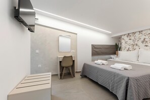 Ein modernes Hotelzimmer mit Bett, Schreibtisch, Stuhl und einem großen Spiegel.