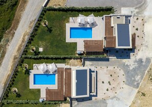 An aerial view of a property with two swimming pools, a covered patio area, and a landscaped garden. - Orama Sunset | Emily Villa (Rhodes)