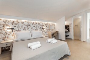 Et moderne hotelværelse med en stor seng, et skrivebord og et walk-in closet.