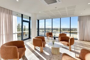 Et moderne hotelværelse med store vinduer, udsigt over bybilledet og moderne møbler.