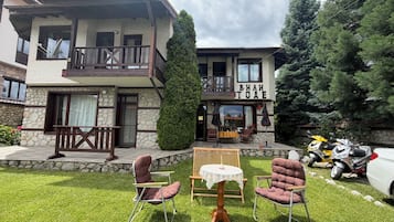 Un bâtiment à deux étages doté d’un balcon, d’une terrasse et d’une enseigne sur laquelle on peut lire « ВИН ТОЕ ».