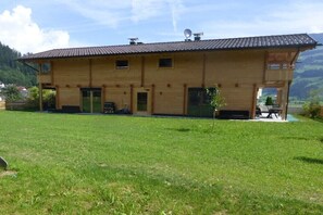 Ein zweistöckiges Haus mit flachem Dach, einer Satellitenschüssel und einem kleinen Garten vor der Fassade.
