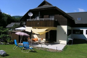 Ein zweistöckiges Haus mit Balkon, Außenbereich und Satellitenschüssel.