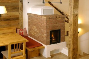 A cozy room with a brick fireplace, wooden furniture, and a staircase. - Chalet in Hochkrimml for 6-14 people (Krimml)