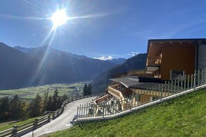 Bergblick mit einem Gebäude, das ein geneigtes Dach und einen Holzzaun hat.
