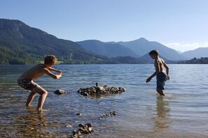 Zwei Personen in einem See vor einer Bergkulisse.