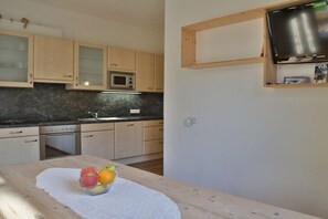 Eine Küche mit Holzschränken, einer Mikrowelle und einem Spülbecken.