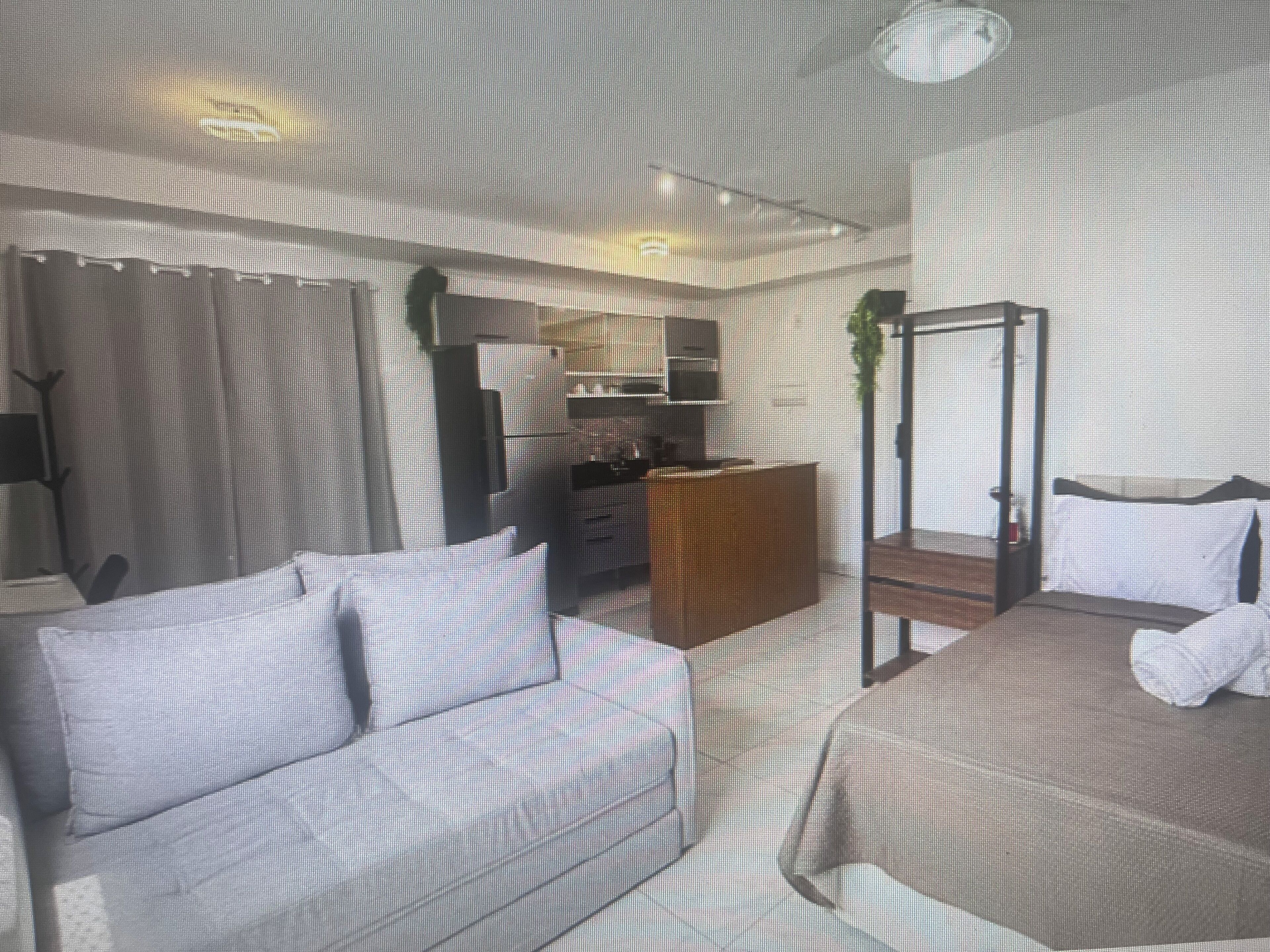 Quarto de hotel com sofá, cama, escrivaninha, guarda-roupa e cama com dossel.