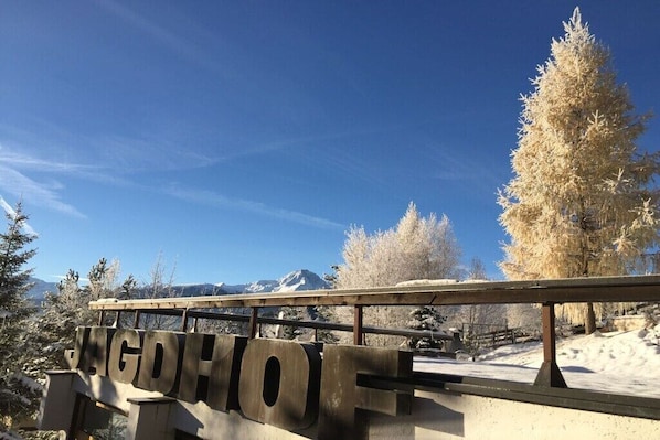 A sign with the word 'VAGDHOF' on a bridge, surrounded by snow-covered trees and mountains. - in the Jagdhof apartment building (Reith bei Seefeld)