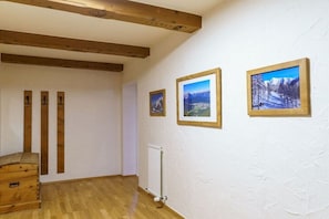 A room with wooden beams, a radiator, and three framed pictures on the wall. - in the Jagdhof apartment building (Reith bei Seefeld)