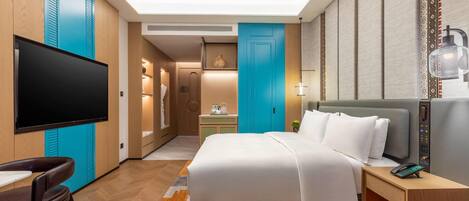 Une chambre d’hôtel comprenant un lit, un bureau, une chaise, une télévision et une salle de bain.