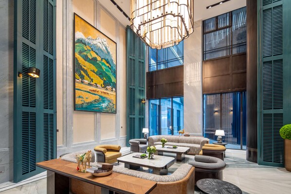 Un hall amplio con techos altos, un cuadro grande y muebles modernos.