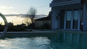 En swimmingpool med et moderne hus i baggrunden.