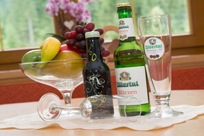 Ein Tisch mit einer Märzen-Bierflasche, einem Glas und einer Obstschale.