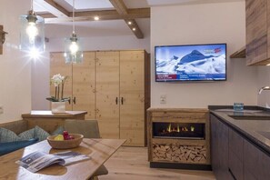 Eine moderne Küche mit eingebautem Herd, Holzschränken und einem an der Wand montierten Fernseher.