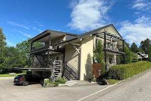 Ein zweistöckiges Haus mit Balkon, Garage und einer Treppe, die zum Obergeschoss führt.