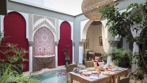 Ein Essbereich mit Pool, roten Türen und einer hängenden Leuchte.
