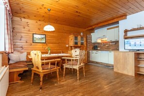 A wooden interior with a dining area, kitchen, and seating. - Type 3 - "Hocharn & Schareck" (Rauris)