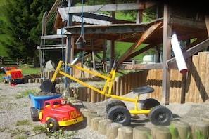 A construction site with a yellow crane, a red toy truck, and a blue dump truck. - Type 3 - "Hocharn & Schareck" (Rauris)