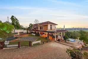Una casa de dos pisos con un porche cubierto, paneles solares y vistas de la ciudad.