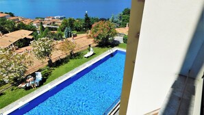 A swimming pool with a view of the sea and surrounding buildings. - Lake View Apartment in Luino for 4 (Luino)