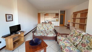 A living room with a sofa, TV, and a small table. - Romantic Lake View Base in Germignaga (Germignaga (VA))