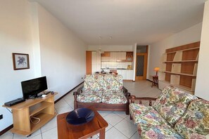 A living room with a sofa, TV, and a small table. - Romantic Lake View Base in Germignaga (Germignaga (VA))