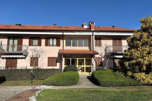 A two-story building with a central entrance, balconies on the upper floor, and a paved driveway leading to the entrance. - Romantic Lake View Base in Germignaga (Germignaga (VA))