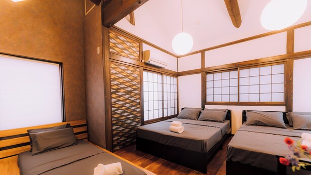 A traditional Japanese-style room with tatami flooring, shoji screens, and a low wooden ceiling. - Shinobi House – 4-Bedroom Ninja-Inspired Stay (大阪市)