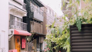 A narrow street with traditional buildings, a wooden door, and a red awning. - Shinobi House – 4-Bedroom Ninja-Inspired Stay (大阪市)