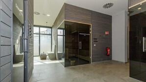 En modern interiör med en entré som har en glasdörr, en brandsläckare och en tydligt synlig skylt som visar utgången i händelse av brand.