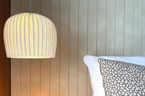 A room with a hanging light fixture and a patterned pillow on a bed. - Modern holiday home with sauna (St. Lambrecht)